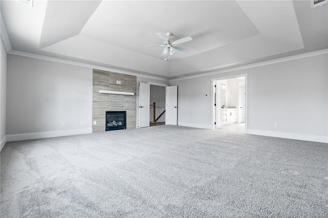 unfurnished living room with carpet, a tray ceiling, and ceiling fan