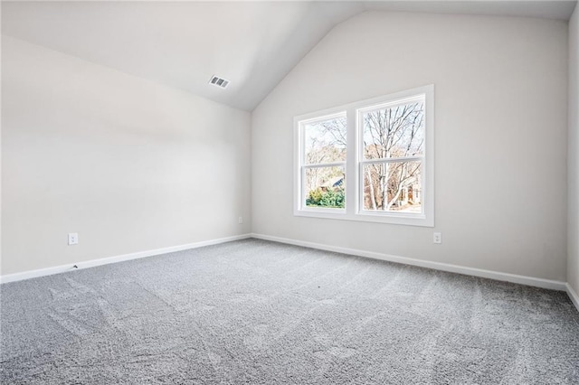 carpeted empty room with lofted ceiling