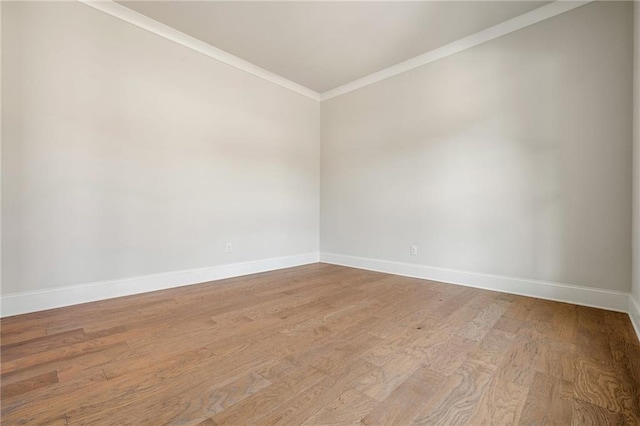 spare room with light wood-type flooring and ornamental molding