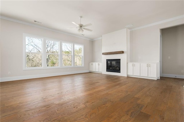 unfurnished living room with hardwood / wood-style flooring, crown molding, and ceiling fan