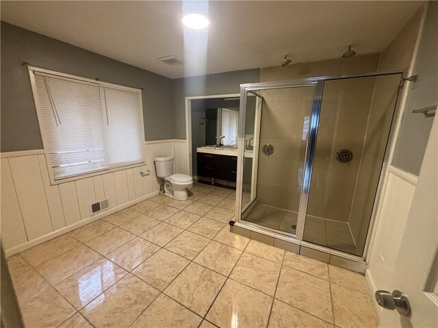 bathroom featuring tile patterned flooring, toilet, an enclosed shower, and vanity