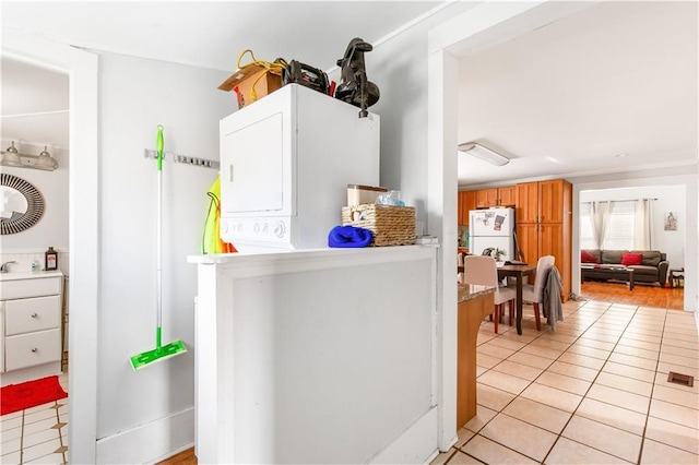 1091 Longley Ave NW, Atlanta, GA 30318 - washroom featuring stacked washer and dryer, laundry area, a sink, and light tile patterned floors