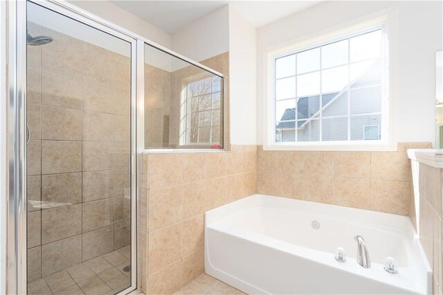 bathroom featuring tile walls and independent shower and bath