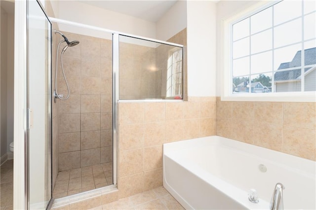 bathroom featuring separate shower and tub, tile patterned flooring, tile walls, and toilet