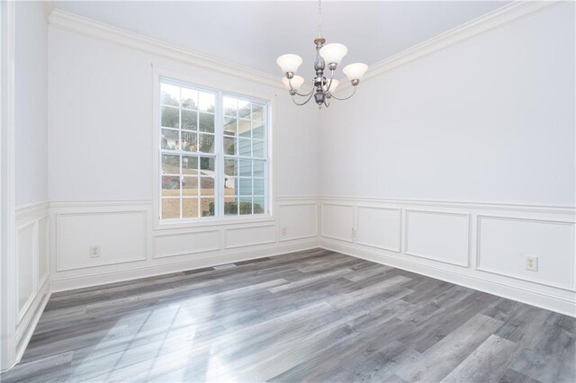 empty room featuring plenty of natural light, ornamental molding, and a notable chandelier