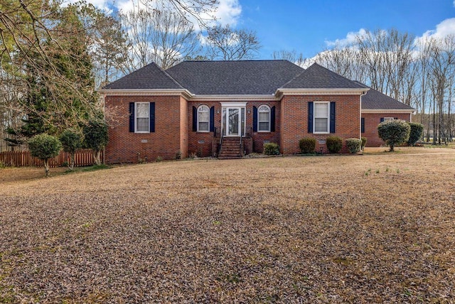 single story home featuring brick siding, a shingled roof, and fence