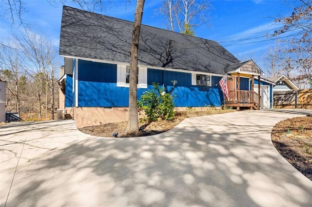view of front of house with crawl space, cooling unit, roof with shingles, fence, and concrete driveway
