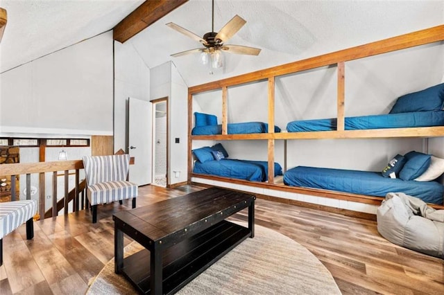bedroom featuring a textured ceiling, wood finished floors, and lofted ceiling with beams