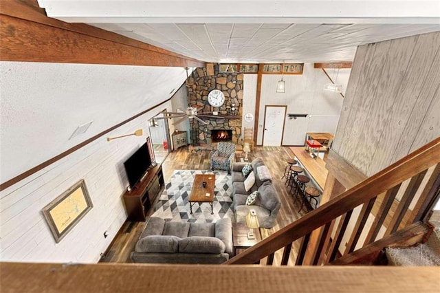 living area with wood finished floors, a fireplace, and lofted ceiling