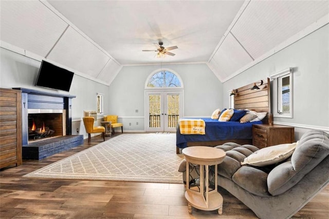 living room with french doors, a ceiling fan, a brick fireplace, lofted ceiling, and wood finished floors