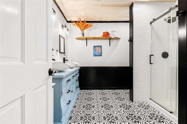 bathroom featuring a wainscoted wall, a stall shower, and vanity