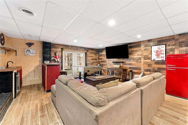 living area with wine cooler, visible vents, french doors, and light wood-style floors
