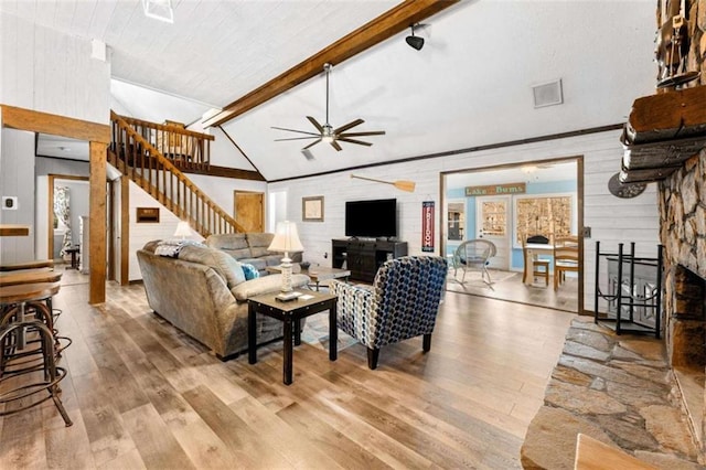 living room with wood finished floors, ceiling fan, lofted ceiling with beams, and stairway