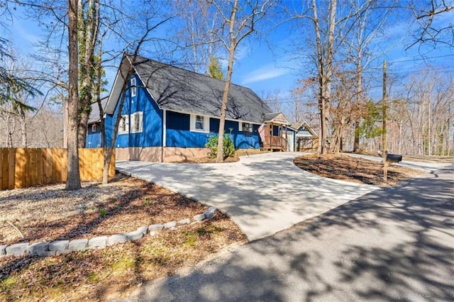 view of front of property featuring concrete driveway and fence