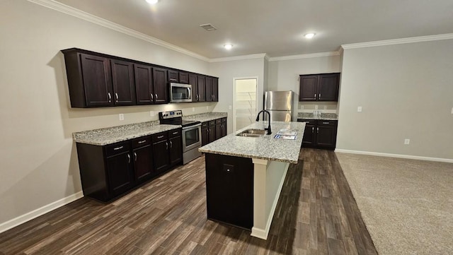 kitchen with appliances with stainless steel finishes, sink, a kitchen island with sink, light stone counters, and dark brown cabinetry