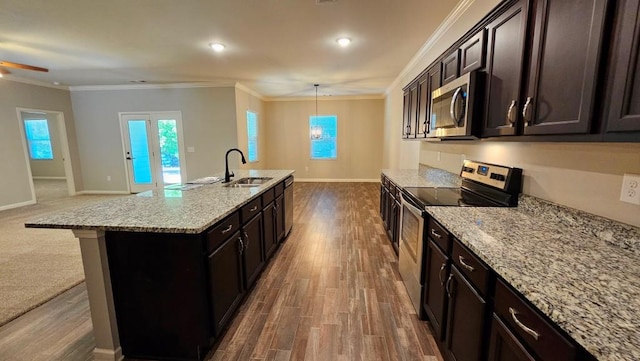 kitchen with sink, crown molding, hanging light fixtures, a center island with sink, and stainless steel appliances