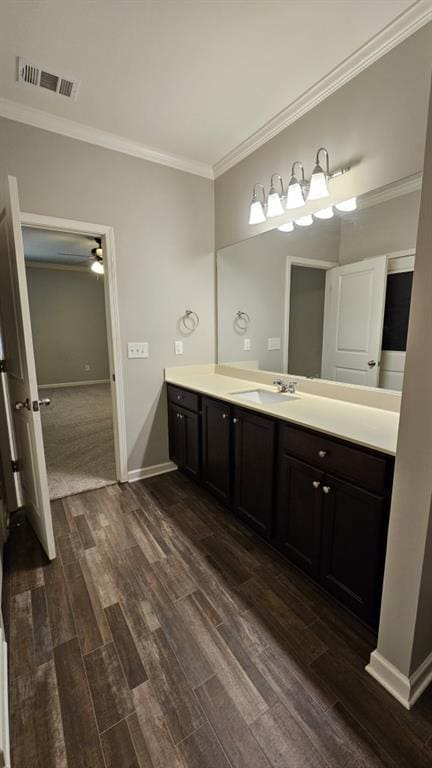 bathroom featuring crown molding, wood-type flooring, and vanity