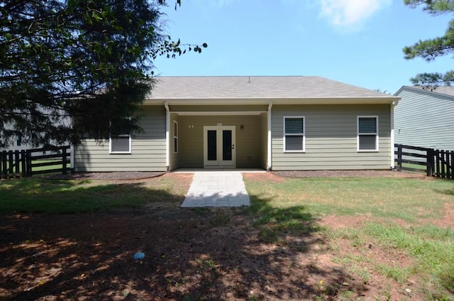 back of house featuring french doors and a lawn