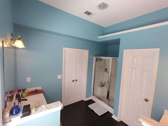 bathroom with vanity, a shower stall, wood finished floors, and visible vents