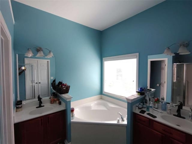 full bathroom featuring a garden tub, a sink, a stall shower, and two vanities