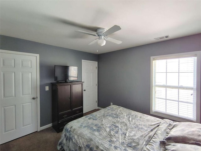 bedroom with visible vents, baseboards, dark carpet, and ceiling fan