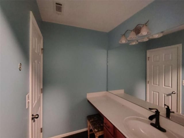 bathroom featuring vanity, baseboards, and visible vents