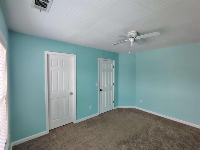 unfurnished bedroom featuring baseboards, carpet flooring, ceiling fan, and visible vents