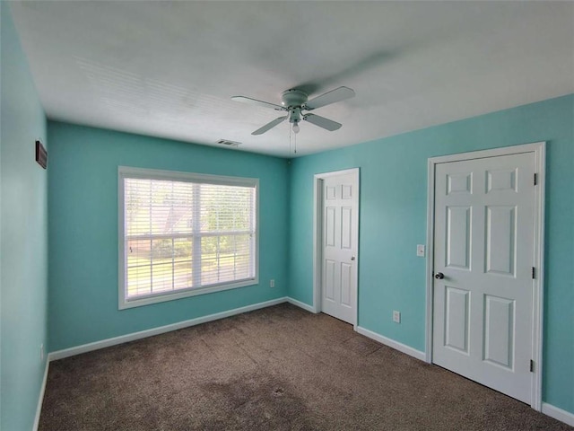 unfurnished bedroom with a ceiling fan, baseboards, visible vents, and carpet