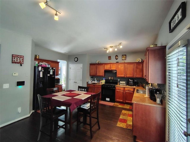 dining space with dark wood-style flooring, baseboards, and track lighting