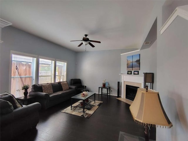 living room with a fireplace with flush hearth, ceiling fan, wood finished floors, and visible vents