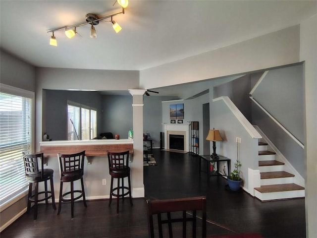 interior space featuring stairway, baseboards, a fireplace, and wood finished floors