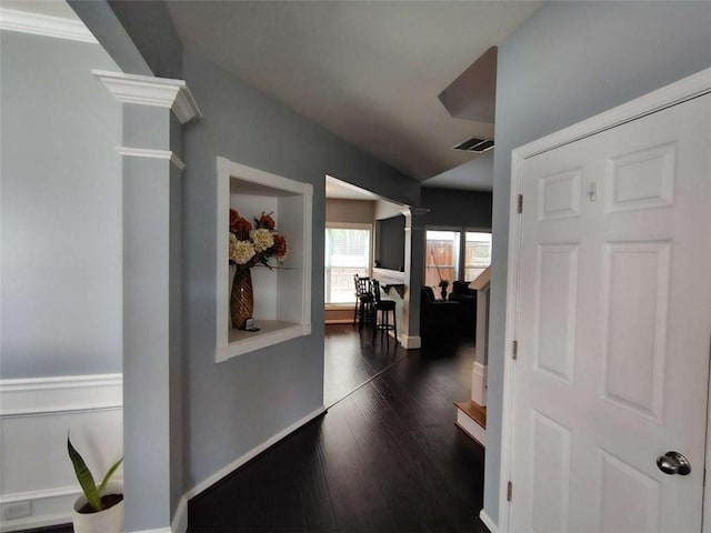 hall with visible vents, decorative columns, baseboards, and dark wood finished floors