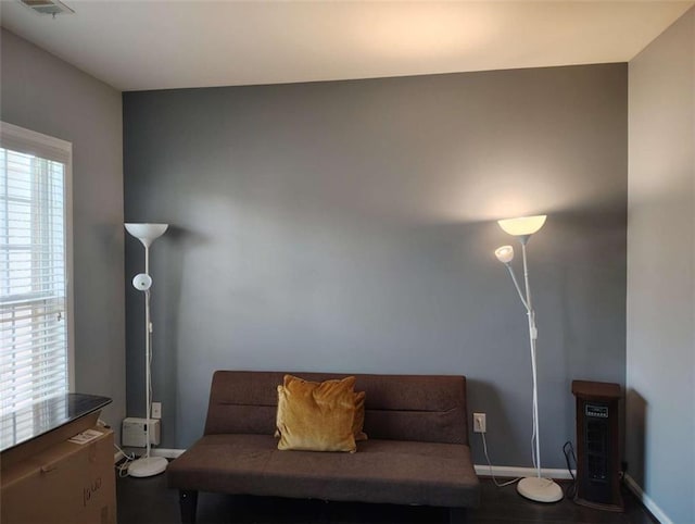 sitting room with baseboards, visible vents, and wood finished floors