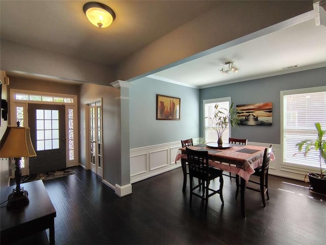 dining area featuring visible vents, ornamental molding, a wainscoted wall, and dark wood-style floors