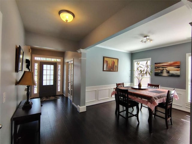 dining area with wainscoting, a decorative wall, and dark wood-style floors