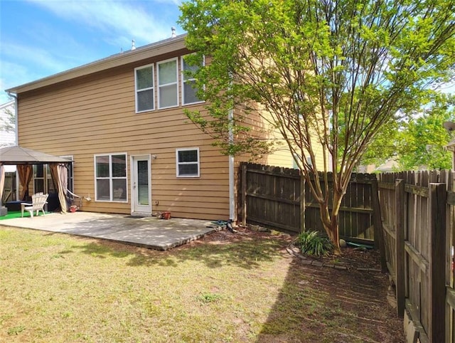 back of house featuring a fenced backyard, a patio, a gazebo, and a lawn