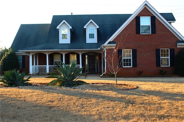 view of front of home featuring covered porch and a front lawn