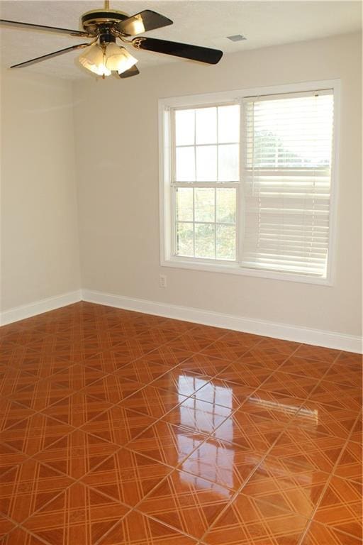 empty room featuring a wealth of natural light and ceiling fan