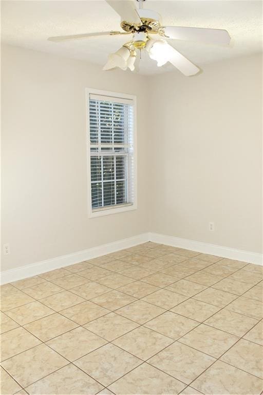 tiled spare room featuring ceiling fan