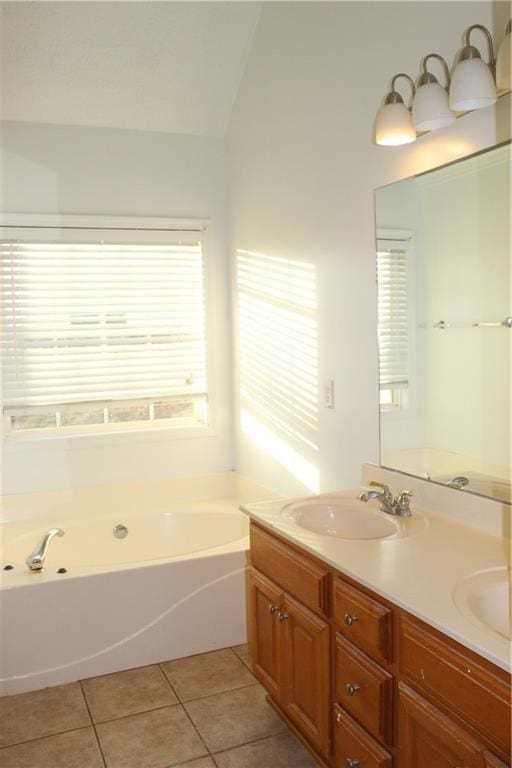 bathroom featuring tile patterned floors, vanity, a tub, and vaulted ceiling