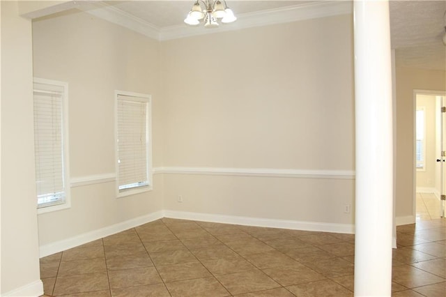 unfurnished room featuring tile patterned flooring, crown molding, and a notable chandelier