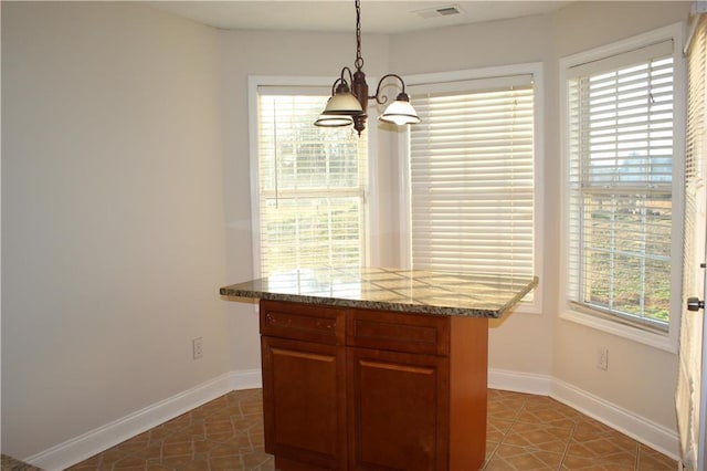 kitchen featuring tile patterned flooring, decorative light fixtures, and a healthy amount of sunlight