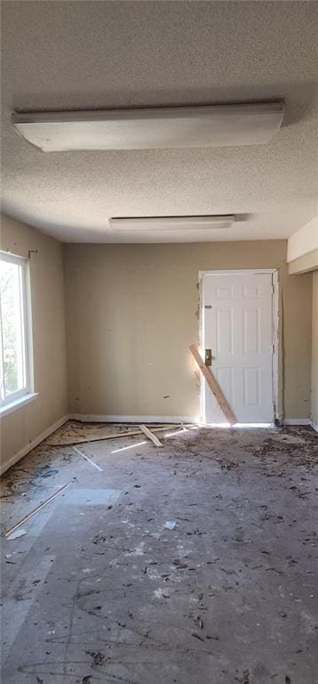 unfurnished room with a textured ceiling