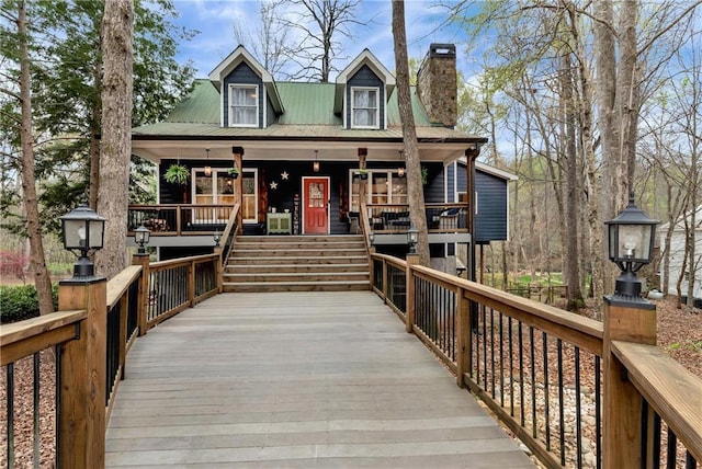 view of front facade featuring a porch and a chimney