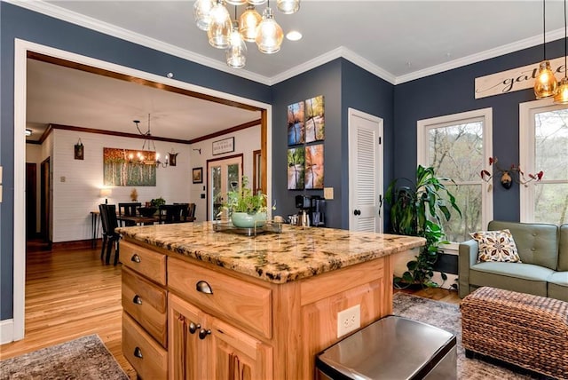 kitchen featuring light stone countertops, light wood finished floors, an inviting chandelier, and ornamental molding