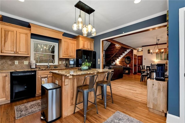 kitchen featuring a chandelier, light wood-type flooring, black appliances, and a kitchen island