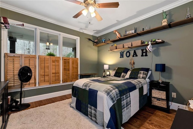 bedroom featuring ornamental molding, baseboards, and wood finished floors