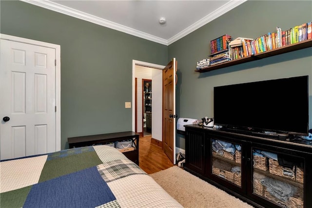 bedroom featuring wood finished floors and ornamental molding