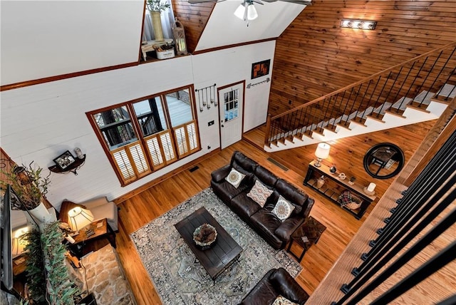 living room with stairway, a ceiling fan, visible vents, high vaulted ceiling, and wood finished floors