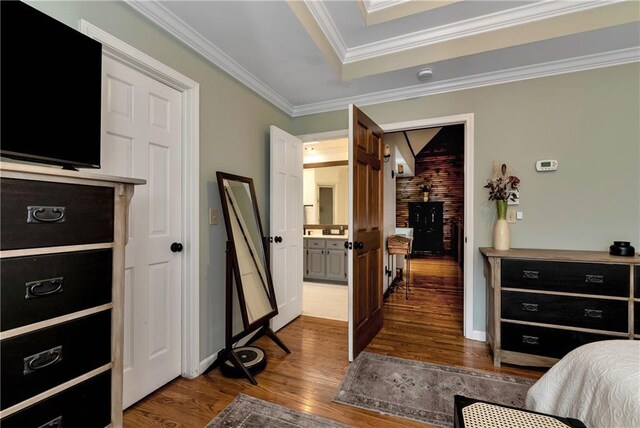 bedroom featuring wood finished floors, baseboards, and ornamental molding